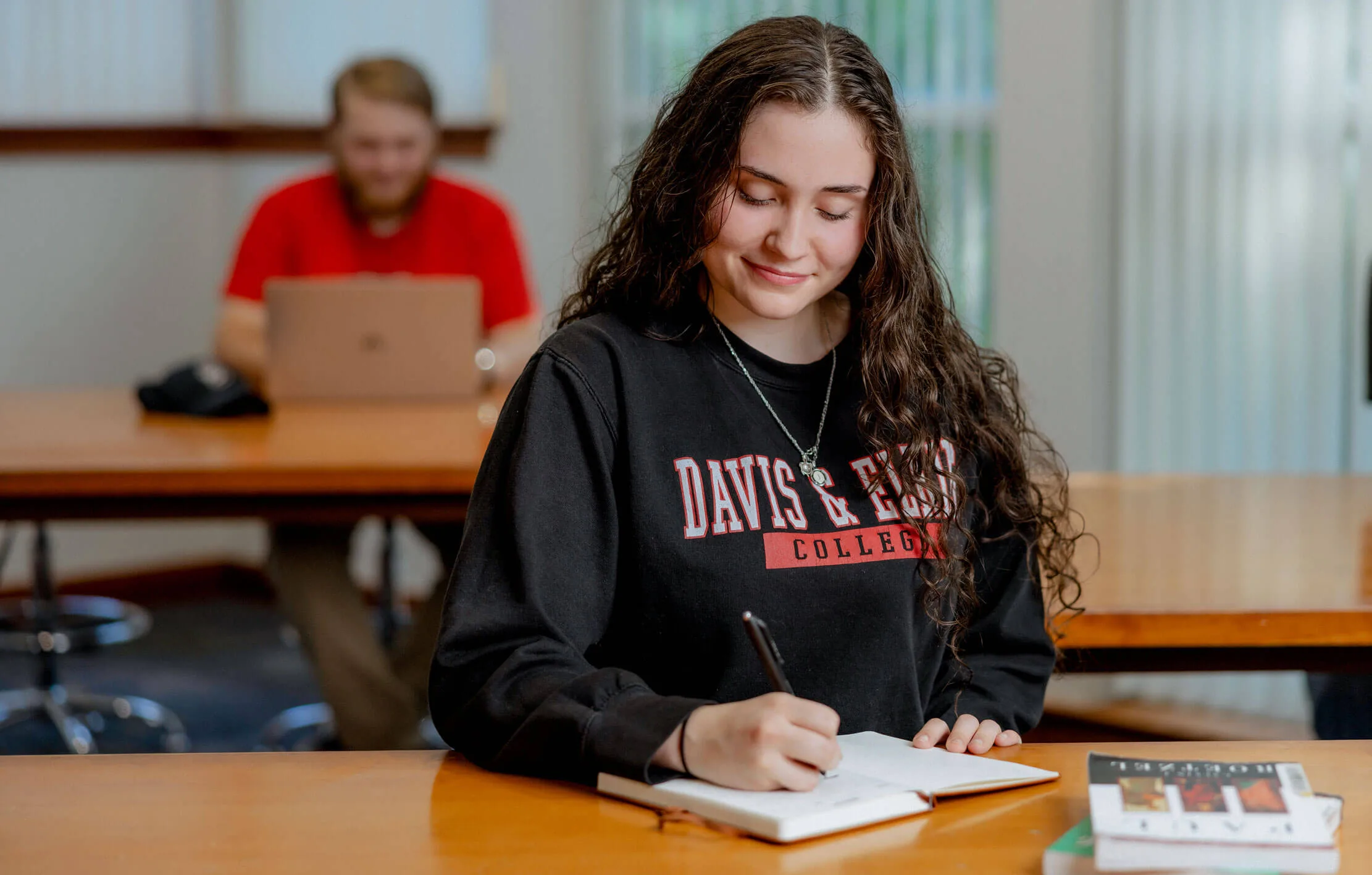 UC Davis student writing in a classroom
