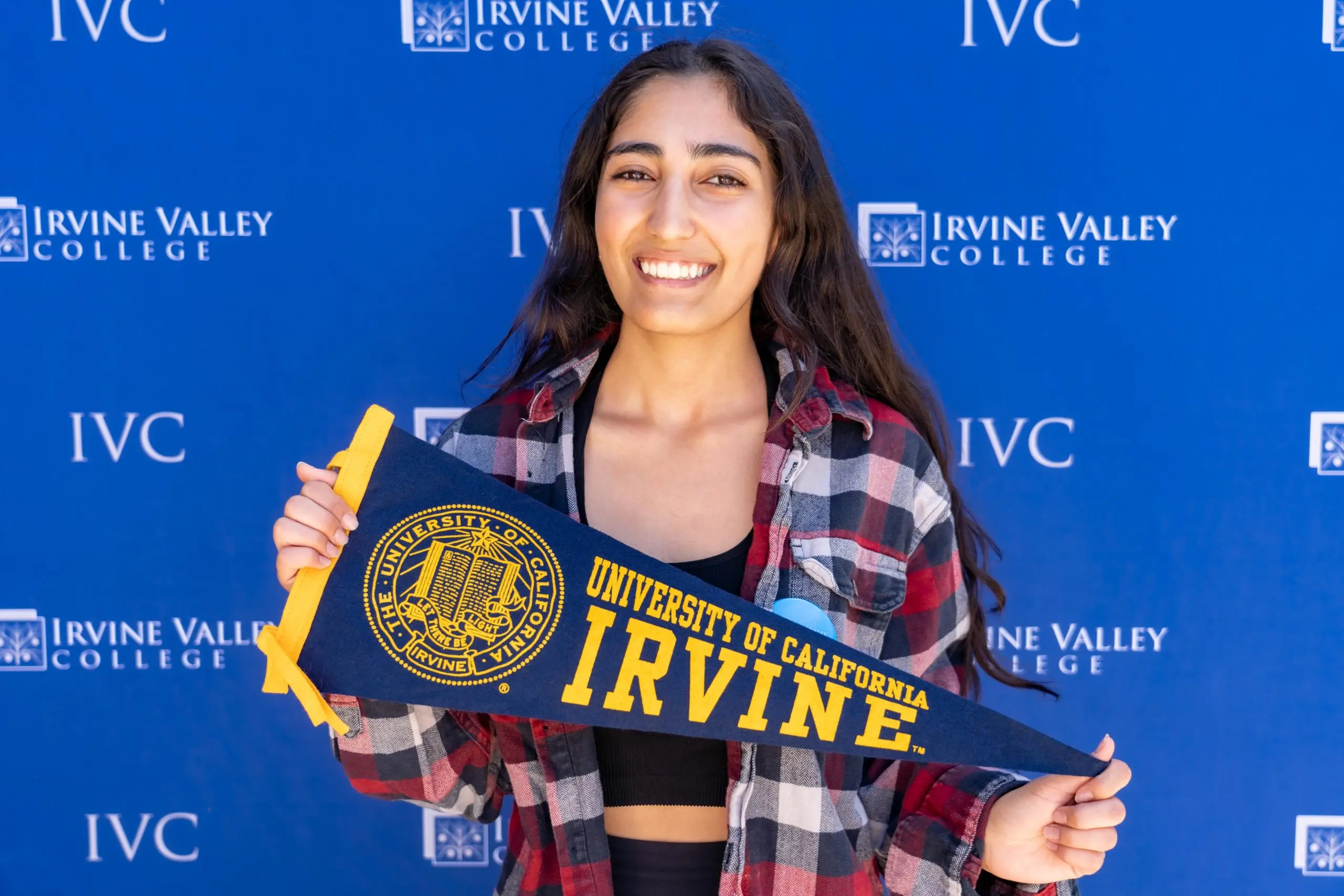 Student celebrating with an Irvine campus pennant